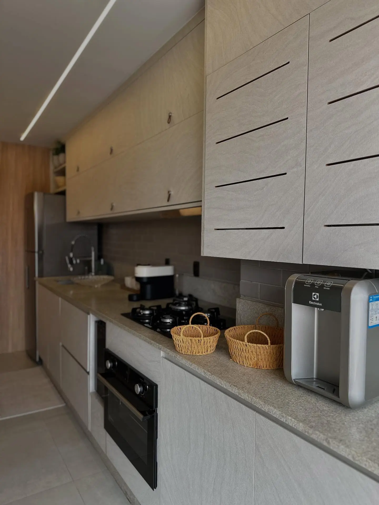 Cozinha gourmet planejada com acabamento em madeira e armários personalizados